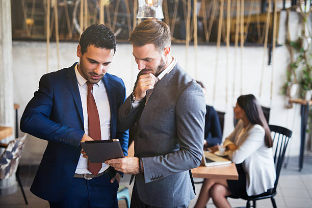 istock Two young businessmen discussing business strategy using digital tablet 615480774