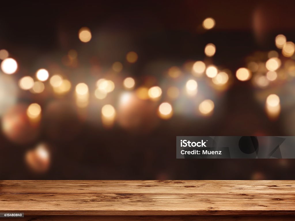 Festive background in front of empty table Festive background with light spots and bokeh in front of a empty wooden table Christmas Stock Photo