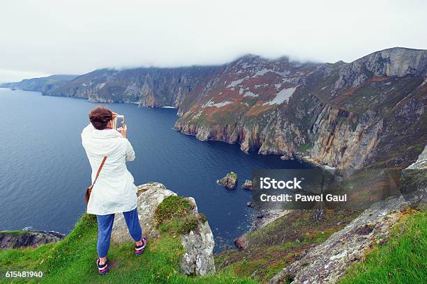 Woman Taking Pictures Of Slieve League Cliffs Stock Photo - Download Image Now - Adult, Cliff, Communication