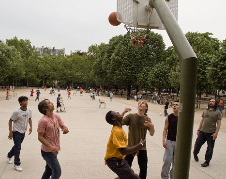 Paris, France, May 17,2006:Group of male friends playing basketball in Paris' Luxembourg Garden basketball court.