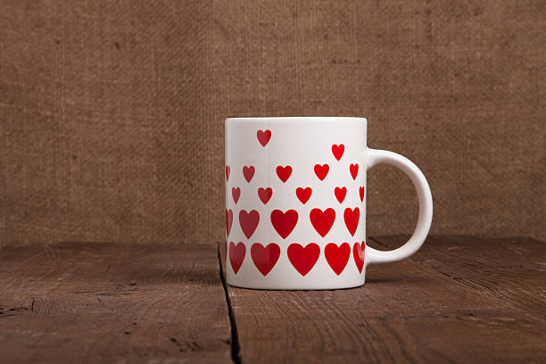 istock Mug with many pictured hearts on the old wooden table. 615483056