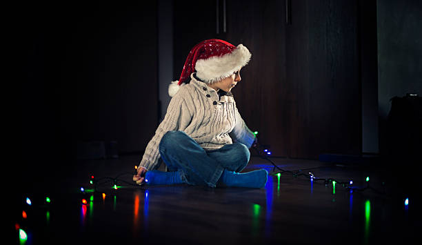 istock Little boy playing with christmas lights 615483116