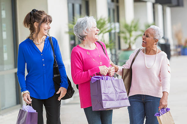 tre donne anziane multietniche fuori a fare shopping - bag senior adult outdoors friendship foto e immagini stock