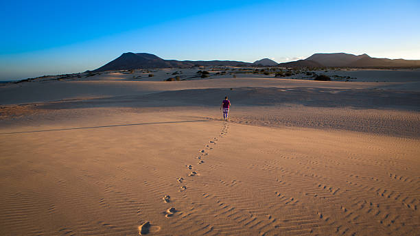 istock woman walking  in the desert 615486650