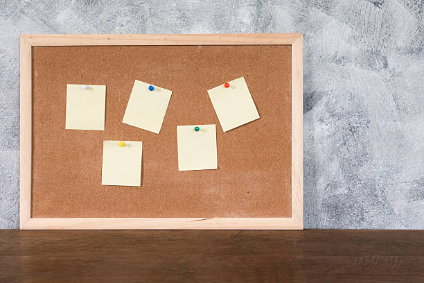 istock Blank papers pin up on cork board over wooden table 615486690