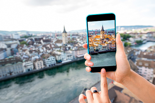 Photographing with smart phone aerial view on Zurich old town in Switzerland