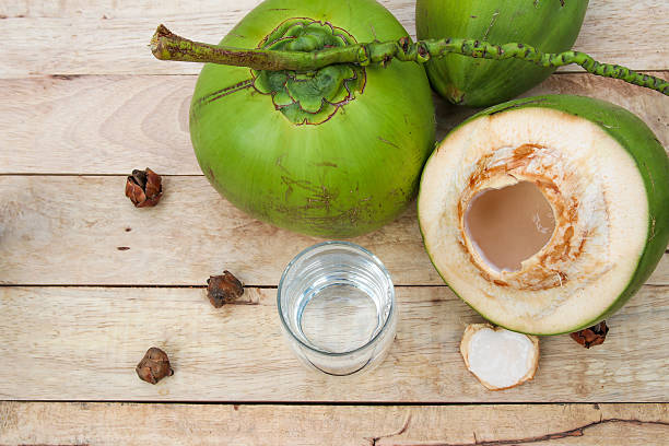 istock Fresh Coconut Water Drink  on wooden  background 615487300