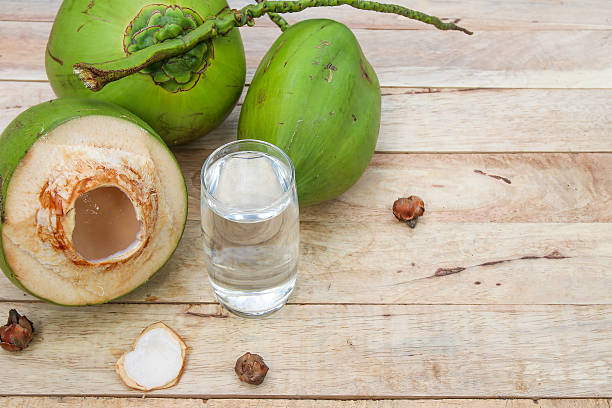 istock Fresh Coconut Water Drink  on wooden  background 615487394