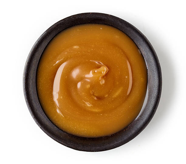 istock Caramel sauce  in round dish isolated on white background 615487772