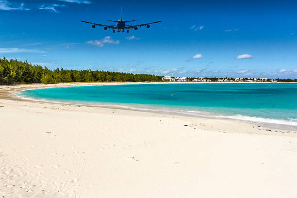 An Airplane approaching Exuma (Bahamas) over Emerald Bay An Airplane approaching Exuma (Bahamas) over Emerald Bay exuma stock pictures, royalty-free photos & images