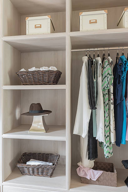 istock modern wooden wardrobe with clothes hanging on rail 615490824
