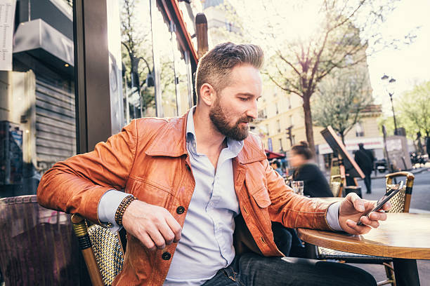 istock young man sitting in sidewalk cafe, Paris 615492330