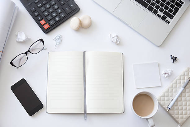 istock Top view of a working desk with open blank notebook 615493136