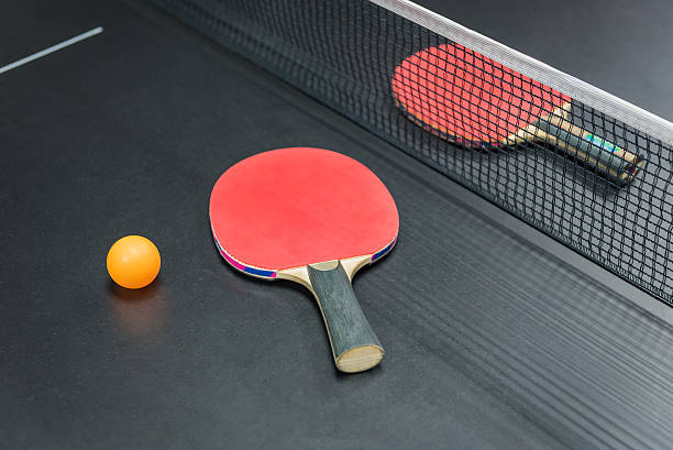 istock table tennis racket with orange ball on black 615493614