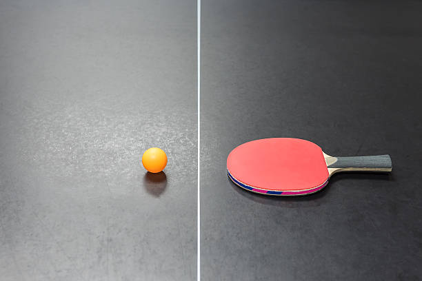 istock table tennis racket with orange ball on black 615493688
