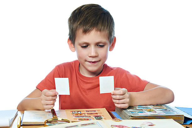 Two boys sit at a wooden table, having fun and smiling while playing mobile games, emphasizing the joy of shared gaming experiences and their strong friendship bond.