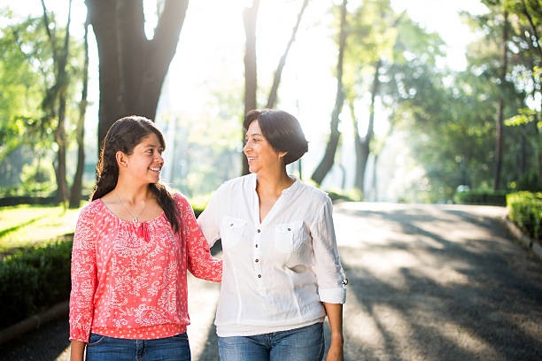 istock Latin mother and daughter standing side by side 615494614