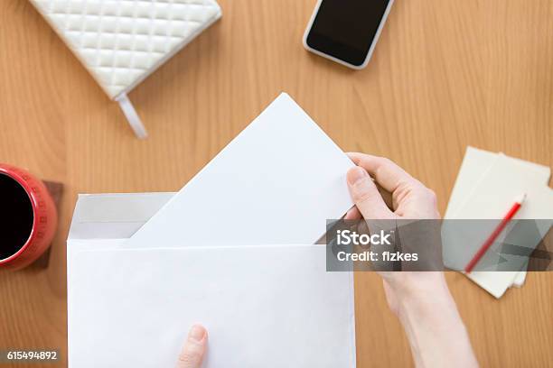 Female Hands Holding An Envelope With A Sheet Over Office Stock Photo - Download Image Now
