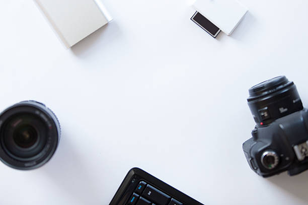 istock White desk with a professional camera and accessoires 615495558