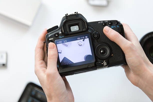 istock Hands holding a camera over the desk 615495626