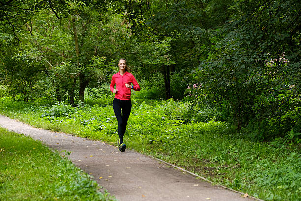 istock Young woman jogging in the park 615495984