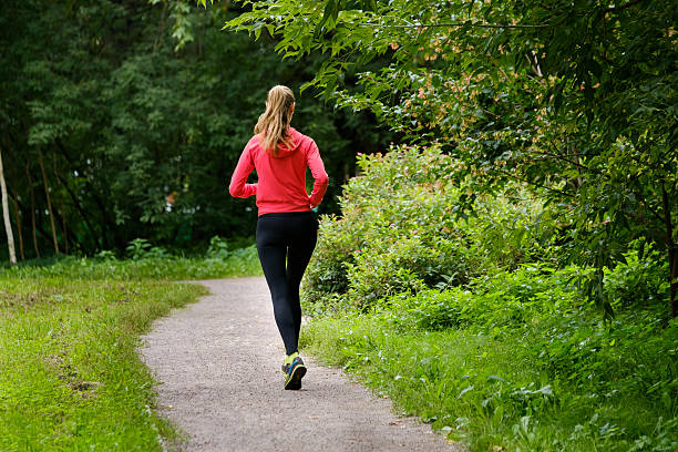 istock Young woman jogging in the park 615496142