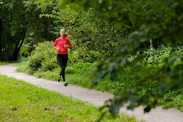 istock Young woman jogging in the park 615496240