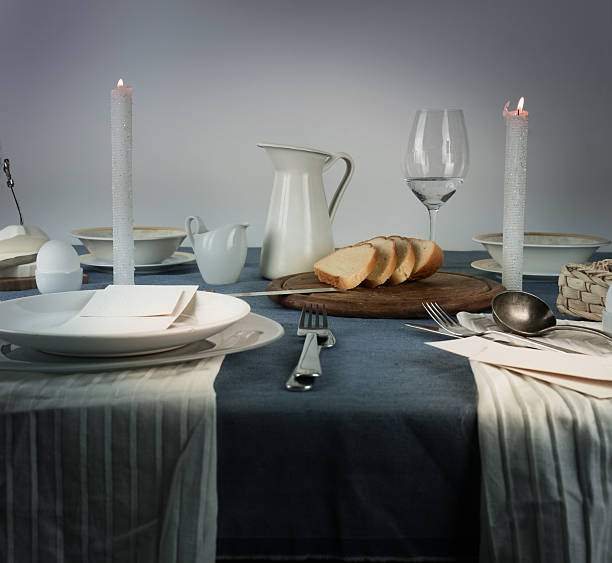 istock still life. jug, glasses, bun, white candles on a blue 615496542