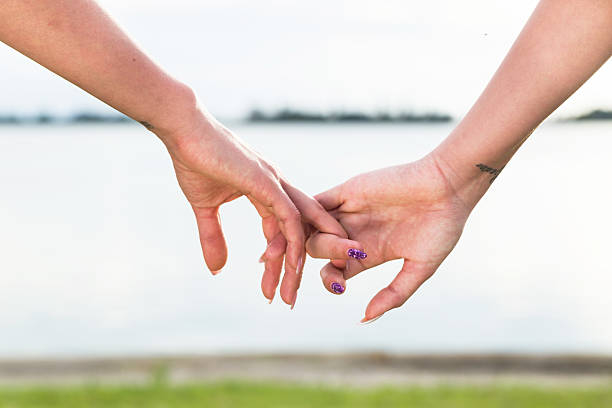 istock Two woman holding their hands in summer sunny day 615498192