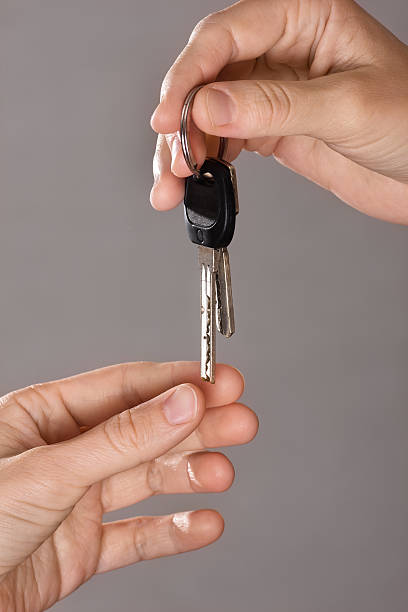 istock hand giving keys another person 615499890