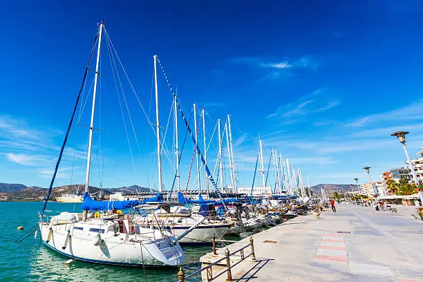 Sailing ships and yachts stand moored in the port of Volos, Greece
