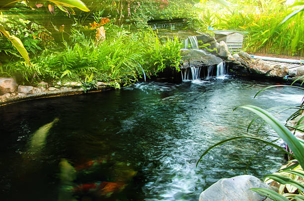 istock Waterfall in garden design with artificial sunlay. 615504394