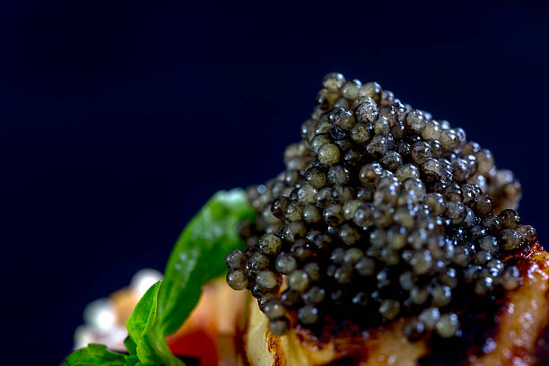 Main course in restaurant. Grilled fish with black caviar