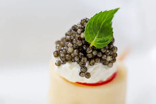 Delicious snack with black caviar and cheese