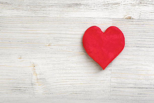 istock Plasticine little red heart laying on a light wooden surface 615511010