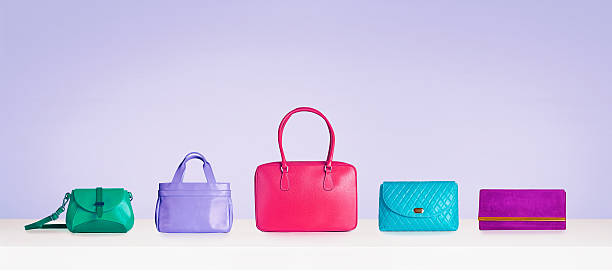 bolsas coloridas e bolsas isoladas em fundo roxo com espaço de cópia. - merchandise luxury equipment fashion industry - fotografias e filmes do acervo