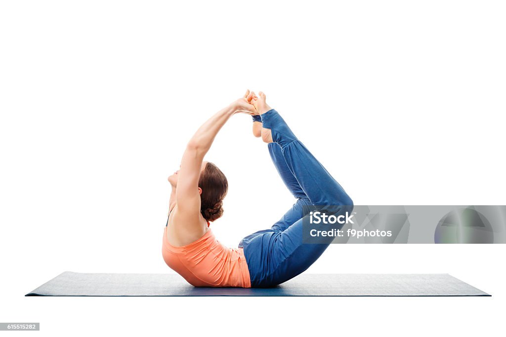 Sporty fit woman practices yoga asana Dhanurasana Sporty fit woman dooing yoga back bend asana Dhanurasana - bow pose isolated on white Adult Stock Photo