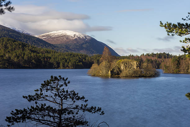 loch an eilein montrant la ruine du château de l’île et la montagne enneigée - aviemore photos et images de collection