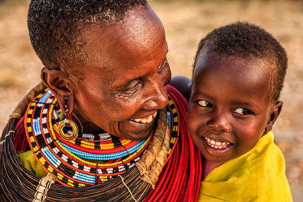 彼女の赤ちゃん、ケニア、東アフリカにキスアフリカの女性 - africa child village smiling ストックフォトと画像