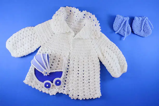 Hand-knit Organic Wool Baby Clothes. Baby shower concept in flat lay