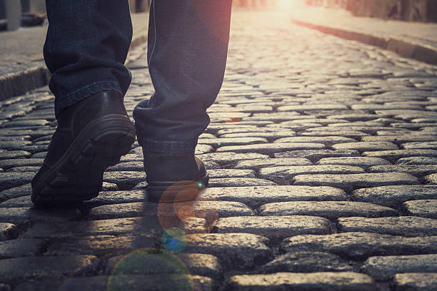 istock man walking along a city road, at sunset 615519938