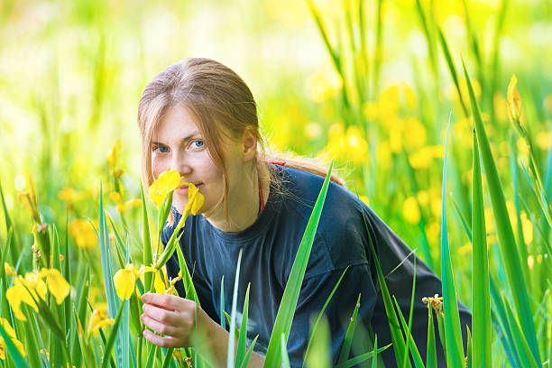 jolie femme blonde sent les fleurs jaunes - aromatherapy single flower flower holding photos et images de collection