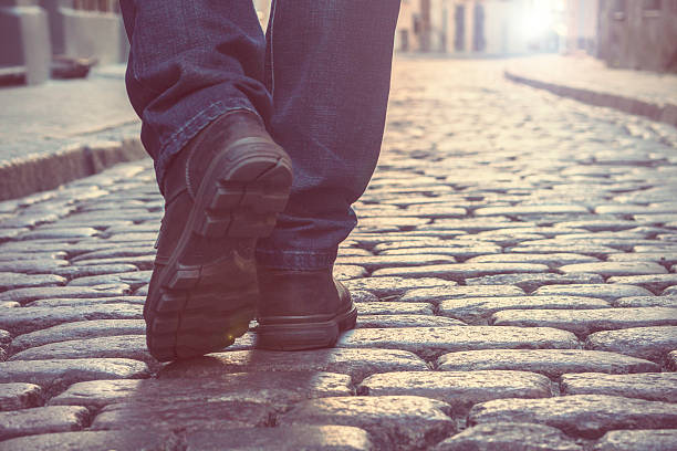 istock man in boots marching on the city road, pavement 615521222