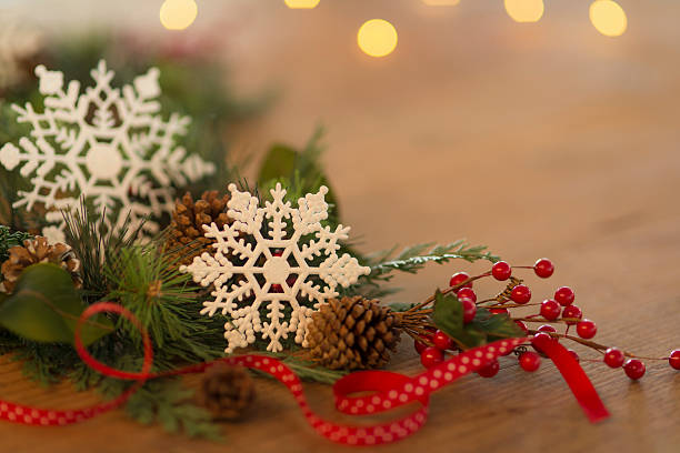 istock Holiday table decorations with snowflakes, pinecones, ribbon, and holly berries 615521402