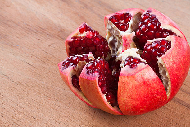 istock ripe pomegranate on wood background. 615521514