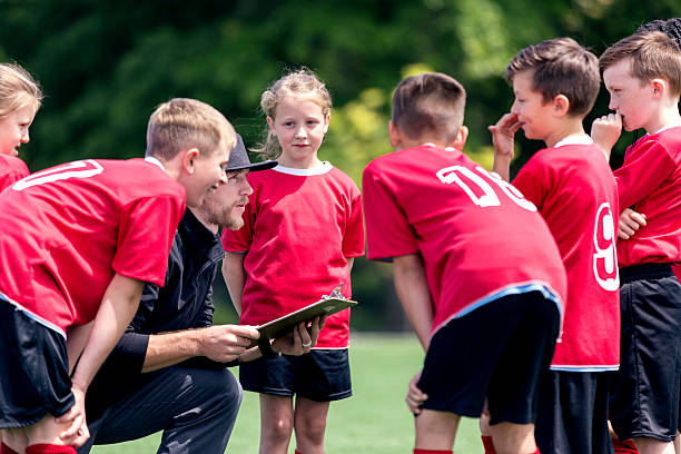 istock Childrens soccer coach talking to his co-ed team 615522132