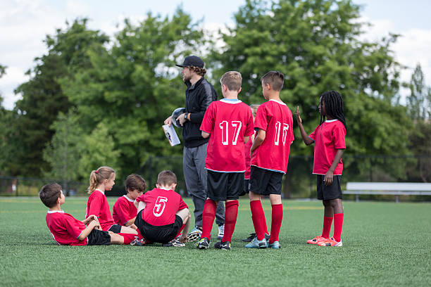 istock Co-ed diverse childrens soccer team midfield with coach 615522194