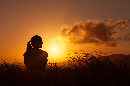 Woman watches the beautiful sunset/sunrise. 