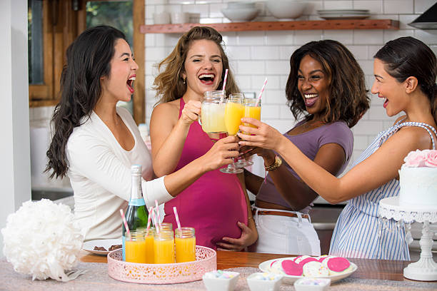 baby shower divertente mimosa cocktail diverse donne gruppo amici etnie - baby shower women home interior indoors foto e immagini stock