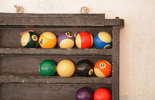 close up pool eight balls in old wooden rack